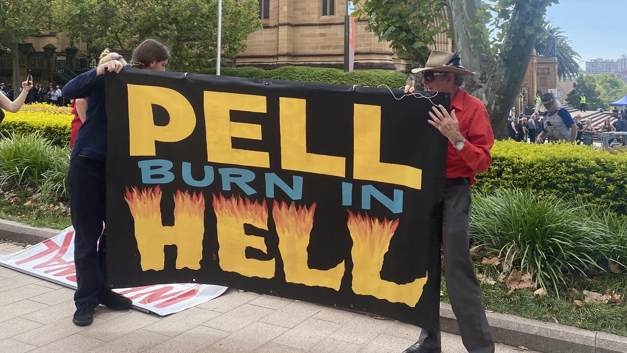 The moment before protesters turned the sign around to face the mourners. Picture: NCA NewsWire