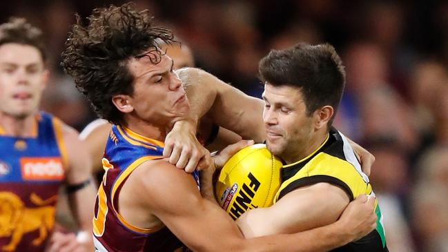 Trent Cotchin attempts to fend off a tackle from Brisbane Lions Cam Rayner. Picture: Michael Willson/AFL Photos via Getty Images.