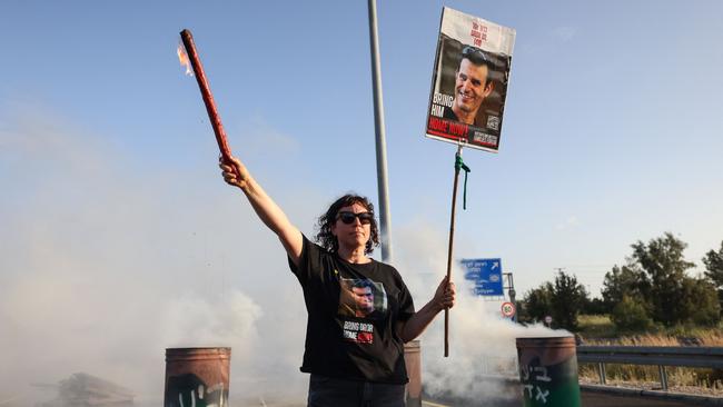 A woman holds a poster bearing the image of Dror Or. Picture: AFP