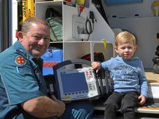 STAY SAFE: Queensland Ambulance Service paramedics, like Derrick Scheuer who showed Max Richter emergency equipment, urges families to stay safe these school holidays. Picture: Sean White