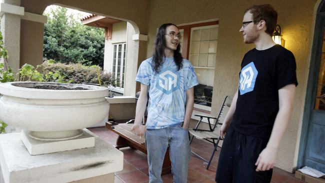 In this Nov. 6, 2014 photo, Brett Borden, left, and Robert Schill take a smoke break outside their 1920s-era Mediterranean-revival home in Lakeland, Fla. They are two of the stars of StreamerHouse, which is a part of Twitch.tv, an online network that attracts tens of millions of visitors, most of whom watch footage of other people playing video games. (AP Photo/John Raoux)