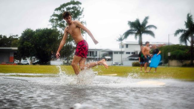 Youths in South-East Queensland play in floodwaters. Picture: Patrick Hamilton / AFP