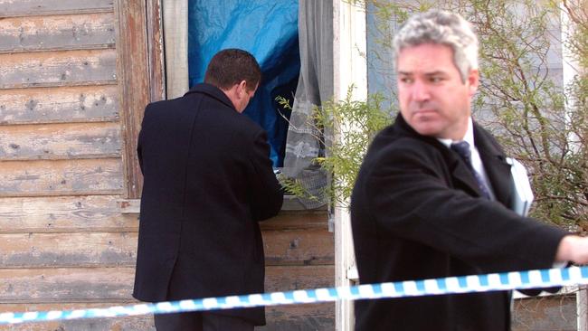 Police inspect the window of the house in Erskine St, North Melbourne, where kidnapped baby Montana Barbaro was found.