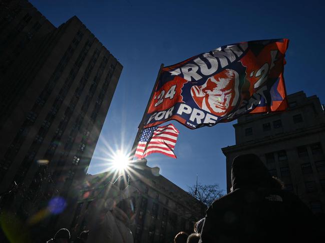 Supporters of US President-elect Donald Trump wave flags during his sentencing. Picture: AFP