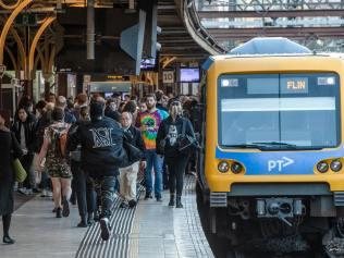 Crowded trains and platforms at afternoon peak at Flinders street station. Passengers on phones and listening to music wait for the train. Picture: Jason Edwards