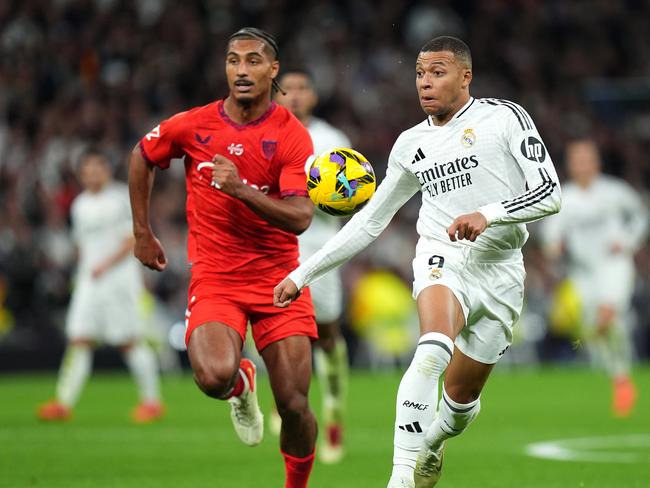 MADRID, SPAIN - DECEMBER 22: Kylian Mbappe of Real Madrid runs with the ball whilst under pressure from Loic Bade of Sevilla FC during the LaLiga match between Real Madrid CF and Sevilla FC at Estadio Santiago Bernabeu on December 22, 2024 in Madrid, Spain. (Photo by Angel Martinez/Getty Images)