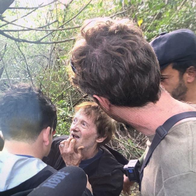 Wagner Fernandes, 66, (centre) a Brazilian tourist who had been lost in scrub on the northern beaches for 48 hours, is greeted by family and friends just a minute after he had been found on a creek bank at the rear of an abandoned semirural property on Wattle Rd Ingleside at about 4.15pm on Friday. Picture: Supplied