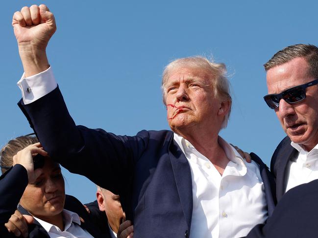 Republican presidential candidate former President Donald Trump pumps his fist as he is rushed offstage after being shot at during a campaign rally in Pennsylvania. Picture: AFP