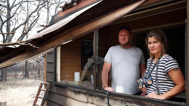 Matt Bath and his partner, Marina Schiewer, survey the ruins of their family home at Wallabi near Taree on the NSW mid-north coast. Picture: Jane Dempster