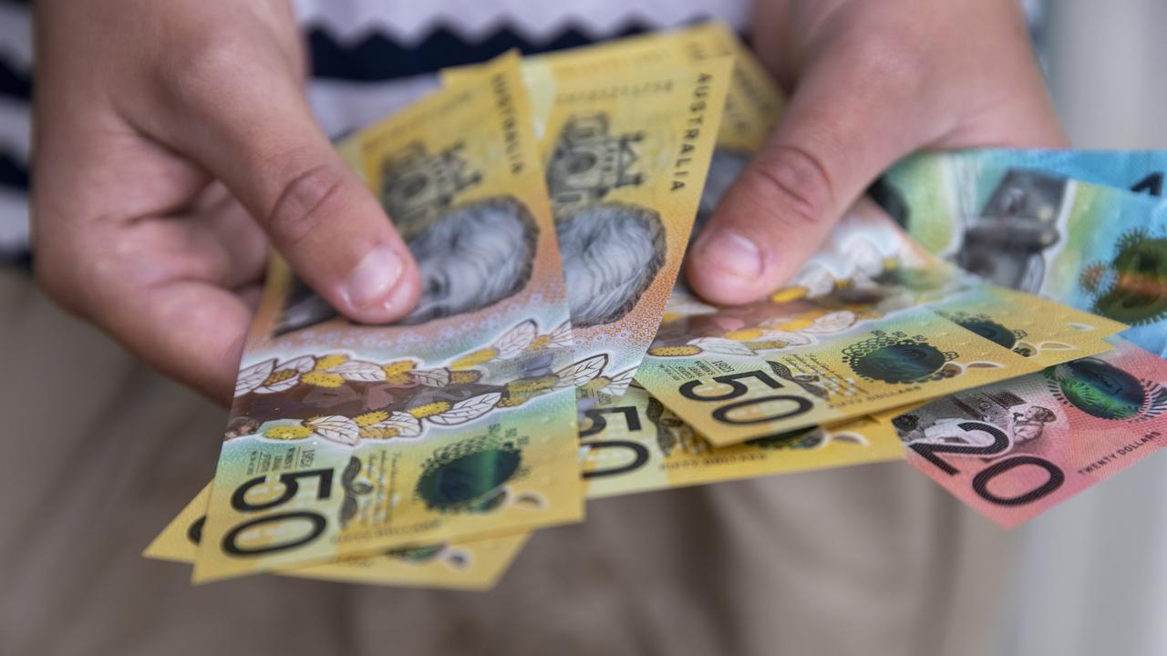 Male person holding some Australian currency. This visual concept evokes ideas around saving money, paying for expenses and investments.