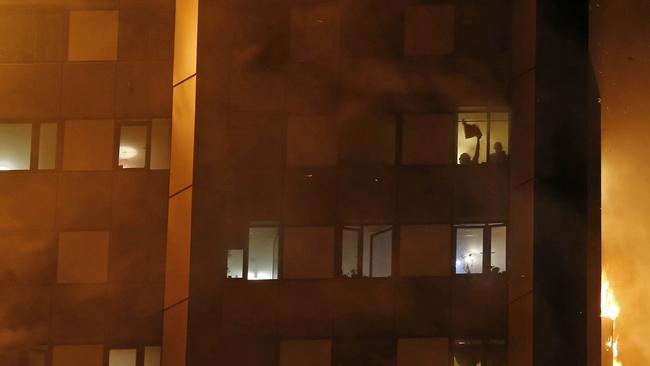 People can be seen in the tower block as the fire takes hold. Picture: Jeremy Selwyn/AUSTRALSCOPE