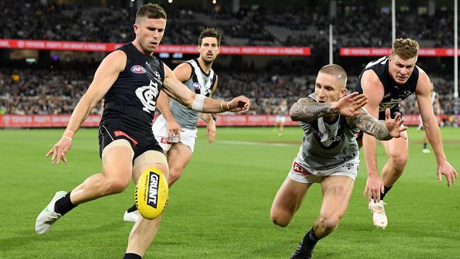 Marc Murphy’s kick is smothered by Hamish Hartlett.