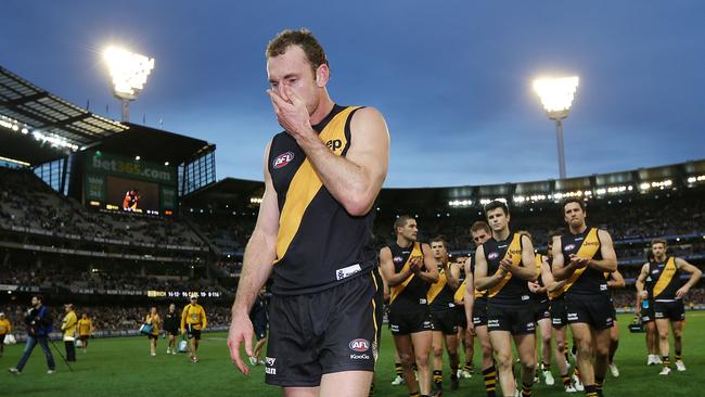 Tuck is clapped off by Tigers teammates in 2013. Picture: Getty