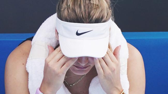 Genie Bouchard holds her head during a break as she struggled to cope with the smoky conditions.