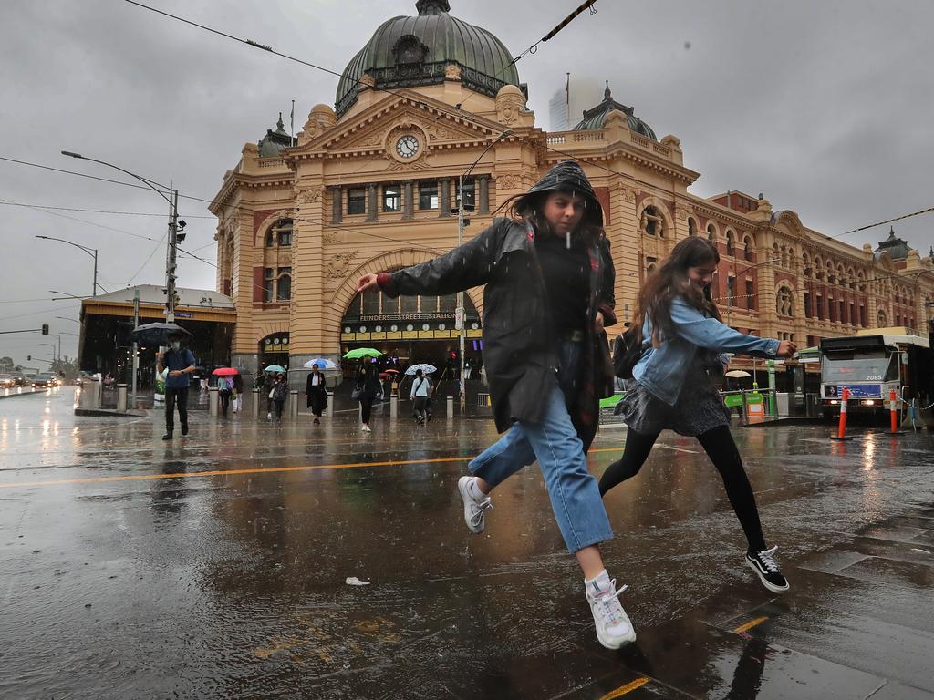 Saturating rain hits Melbourne mid-summer. Avoiding puddles at Flinders st. Picture: Alex Coppel.