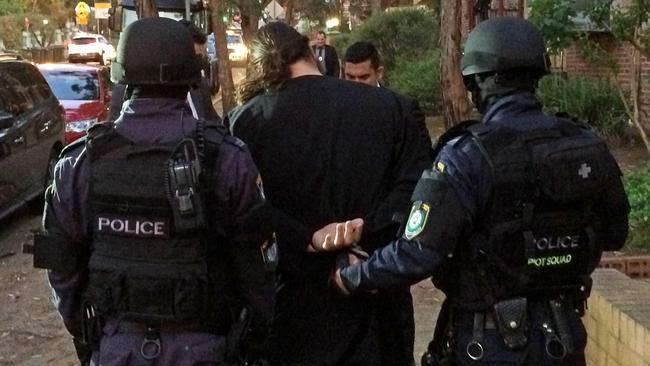 Cuffed ... Riot squad officers lead away 18-year-old man at Wentworthville. Picture: Supplied