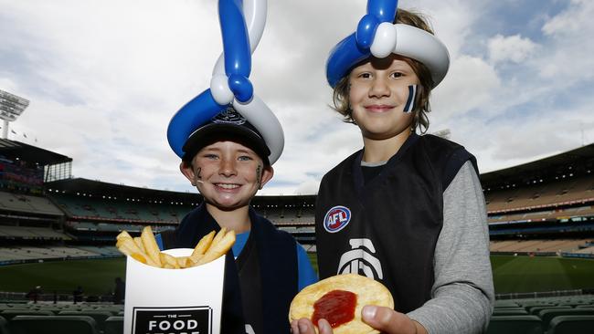 Carlton fans Jacob Sossi (left) and Taylen Wulf (right) enjoy a pie and chips