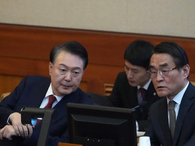 South Korea's impeached President Yoon Suk Yeol (L) talks with one of his lawyers Bae Bo-yoon (R) upon his arrival for a hearing of his impeachment trial over his short-lived imposition of martial law at the Constitutional Court in Seoul on February 11, 2025. (Photo by Lee Jin-man / POOL / AFP)