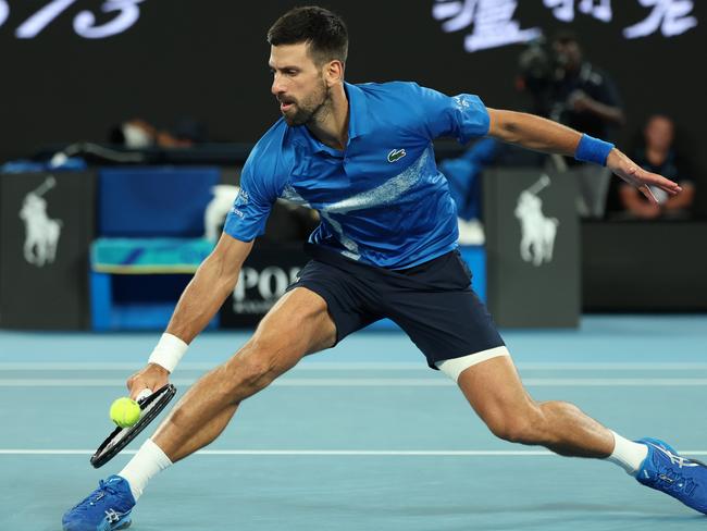 MELBOURNE, AUSTRALIA - JANUARY 21: Novak Djokovic of Serbia plays a backhand against Carlos Alcaraz of Spain in the Men's Singles Quarterfinal match during day 10 of the 2025 Australian Open at Melbourne Park on January 21, 2025 in Melbourne, Australia. (Photo by Clive Brunskill/Getty Images)