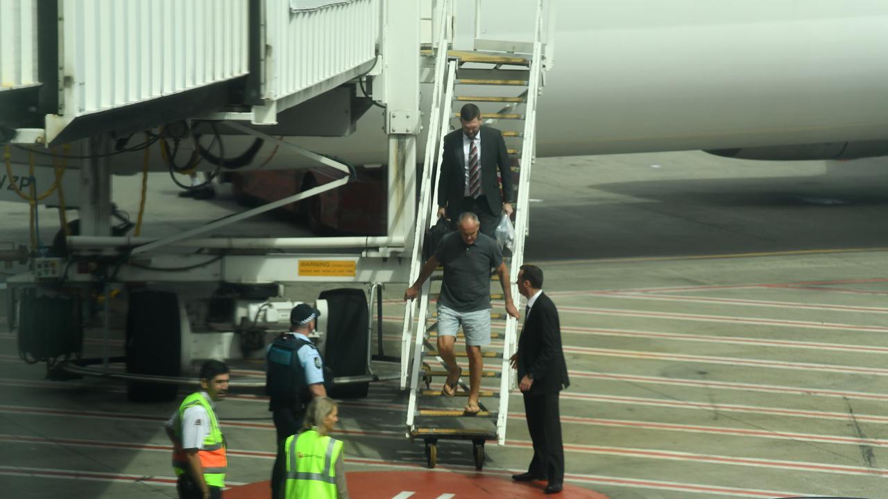 Chris Dawson is escorted by NSW Police detectives off a QANTAS flight as he is extradited from the Gold Coast. Picture: AAP Image/Dean Lewins