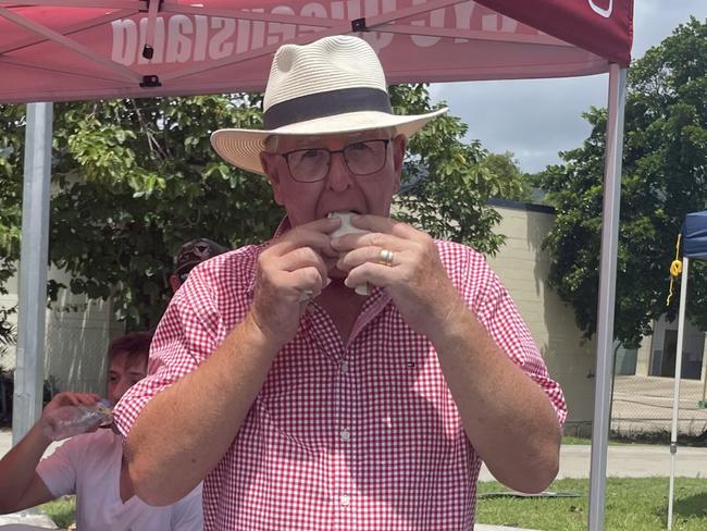 Whitsunday Regional Council mayoral candidate Philip Batty tucking into the traditional democratic sausage. Picture: Estelle Sanchez