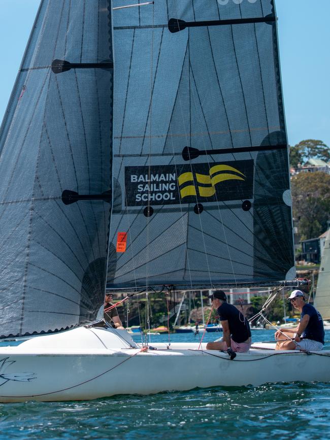 A yacht from the club’s sailing school pierces the blue water. Picture: Thomas Lisson