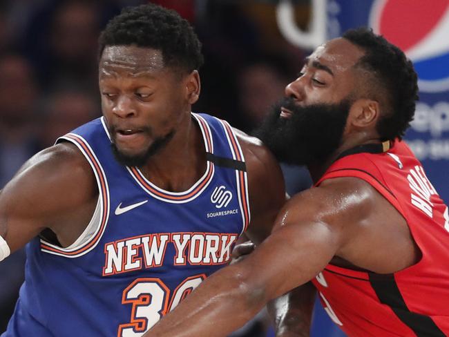 Houston Rockets guard James Harden, right, tries to tip the ball away from New York Knicks forward Julius Randle (30) beneath the Knicks' basket during the first quarter of an NBA basketball game in New York, Monday, March 2, 2020. (AP Photo/Kathy Willens)