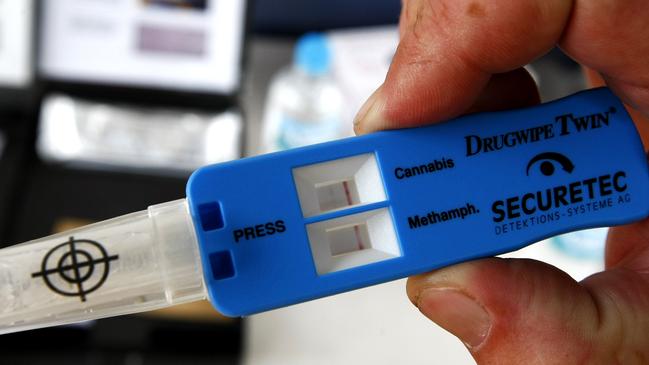 Police officer looking at a positive drug wipe's from a driver. The test returned a positive reading for marijuana (two red lines at the top).