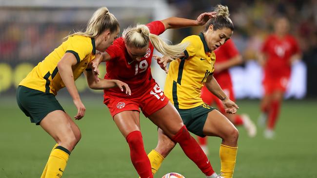 \Adriana Leon of Canada competes for the ball against Charlotte Grant and Katrina Gorry of the Matildas.