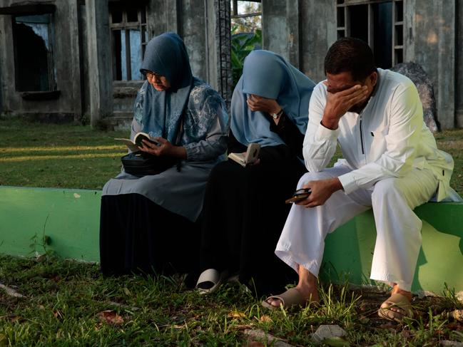 Mourners react as they gather at the Ulee Lheue mass grave. Picture: AFP