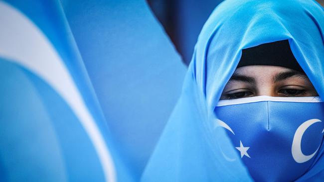 Members of the Women Muslim Uighur minority hold placards and flags of east Turkestan as they demonstrate near China’s consulate in Istanbul during the International Women Day.