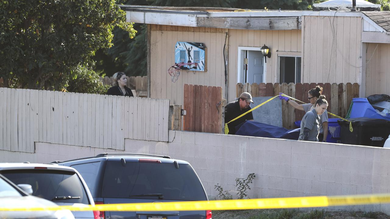 A body is carried out on a gurney at the home where two adults and three children died from gunshot wounds. Picture: Hayne Palmour IV/The San Diego Union-Tribune via AP