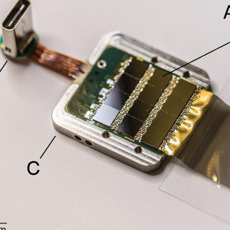 A packaged Neuralink sensor with a USB-C port for connection.