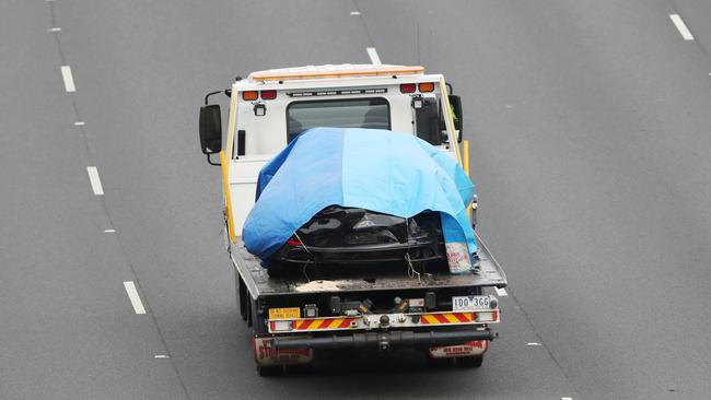 The Porsche involved is driven away under a cover. Picture: David Crosling