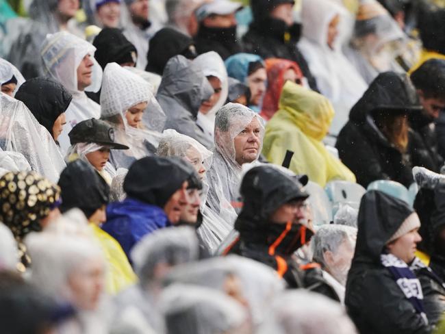 Footy fans wear raincoats as rain falls during the Round 21 AFL match between the Richmond Tigers and the Carlton Blues at the MCG in Melbourne, Sunday, August 11, 2019. (AAP Image/Michael Dodge) NO ARCHIVING, EDITORIAL USE ONLY