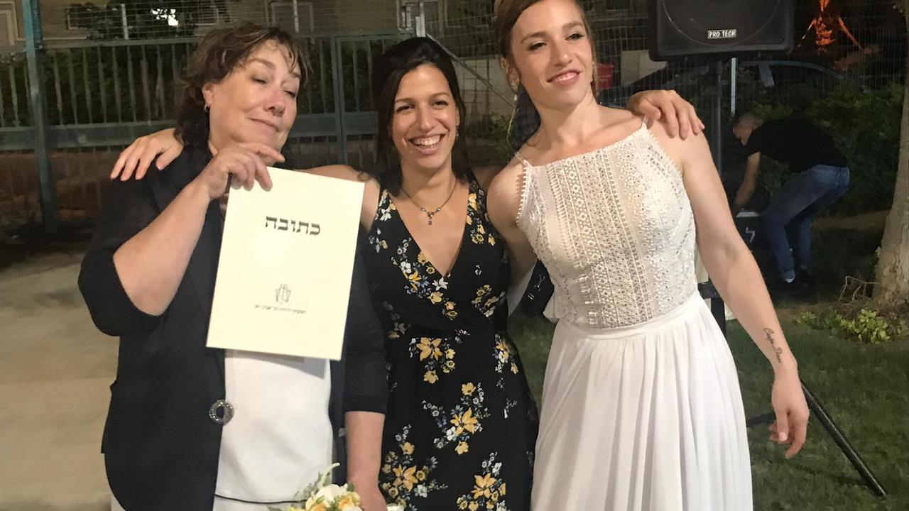 Galit Carbone, left, who was born and raised in Sydney before settling in Israel in her late teens, was killed by Hamas in the October 7 attacks. She is pictured with her daughter Maia, middle, and Nicole, right, on Nicole’s wedding day. Picture: supplied