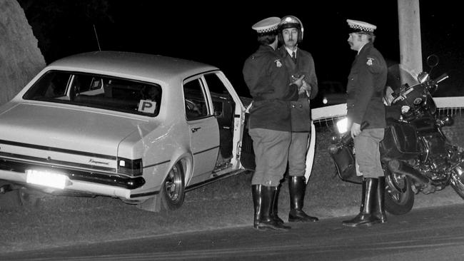 1980. Police stand beside Thomas Cooper’s car after it crashed at Beaumaris Yacht Club carpark. Cowboy killer murder. Neg: 800818