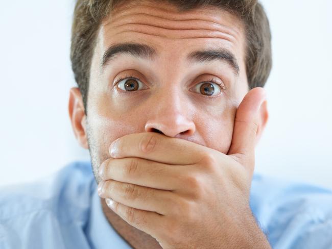 Portrait of a young businessman covering his mouth with his hand, generic hand over mouth