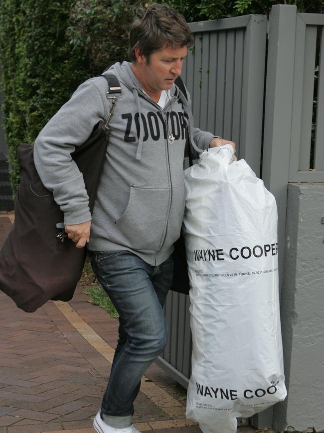 Cooper leaving his home under police supervision in 2008.