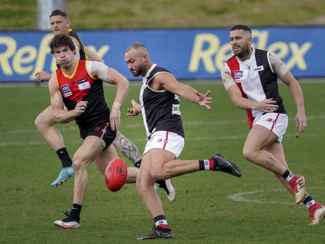 Madi Andrews takes a kick for St Kilda City as Dingley’s Nathan Freeman closes in. Picture: Valeriu Campan