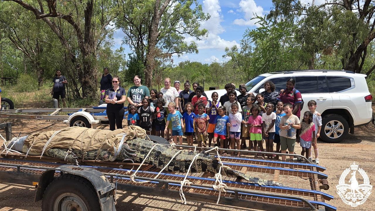 Students from Timber Creek Primary School get a close-up look at the captured crocodile as rangers deliver an important lesson on croc safety. Picture: NT Police / Sourced.