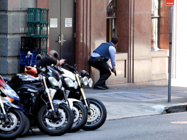 A police officer approaches the Lindt Cafe in the early stages of the siege