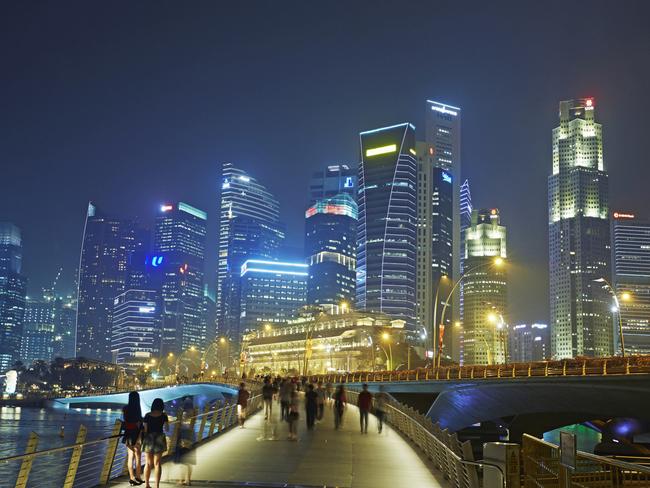 Syline of skyscrapers in the financial district of Singapore and Marina Bay illuminated at night . Picture: Getty Images