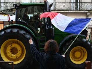 A John Deere and its driver win local support as they roll along a fashionable street in Agen, France