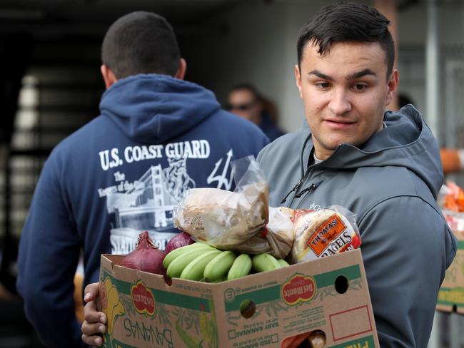 A US Coast Guard member carries a box of free groceries during a food giveaway on January 19 in Novato, California. As the partial government shutdown enters its fourth week, an estimated 150 US Coast Guard families in the San Francisco Bay Area, who are currently not being paid, received free groceries during an event organised by the San Francisco-Marin Food Bank and the North Bay Coast Guard Spouses Club. Picture: Justin Sullivan/Getty Images/AFP