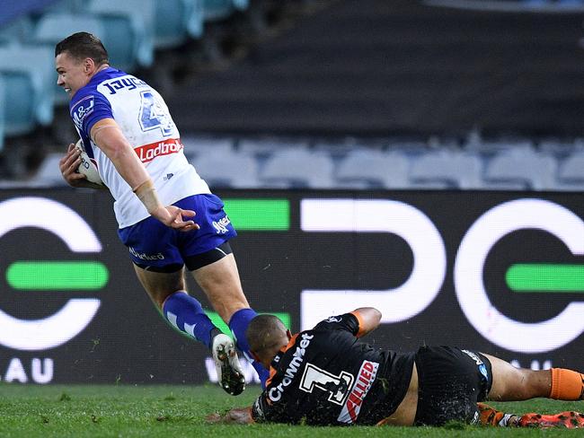 Kerrod Holland leaves Moses Mbye in his wake as he heads for the tryline. Picture: AAP