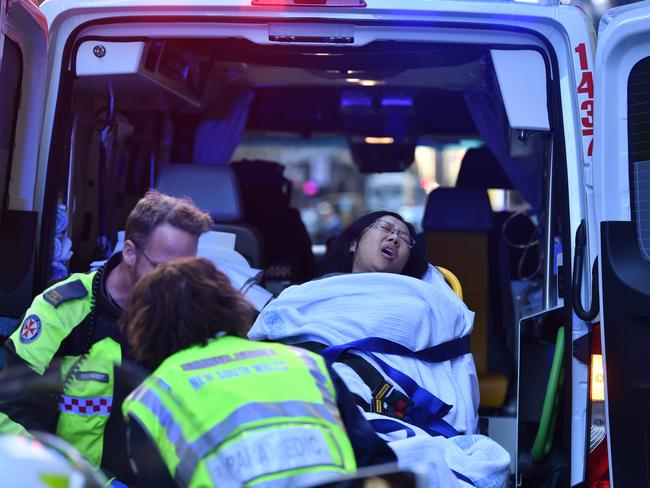 The woman in pain being transported into an ambulance after being stabbed at the corner of King and York Street in Sydney. Picture: AAP