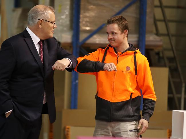 Prime Minister Scott Morrison bumps elbows with a DisplayWise employee in Sydney on Monday. Picture: Mark Kolbe