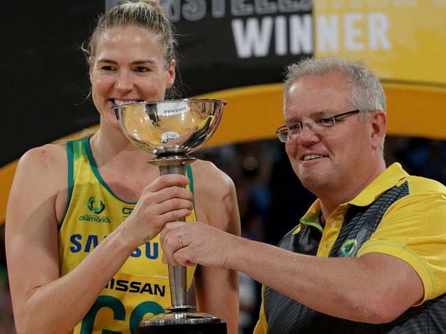 Prime Minister Scott Morrison presents the Constellation Cup to Caitlin Bassett of Australia after Game Four of the Constellation Cup between Australia and New Zealand at RAC Arena in Perth, Sunday, October 27, 2019. (AAP Image/Richard Wainwright) NO ARCHIVING