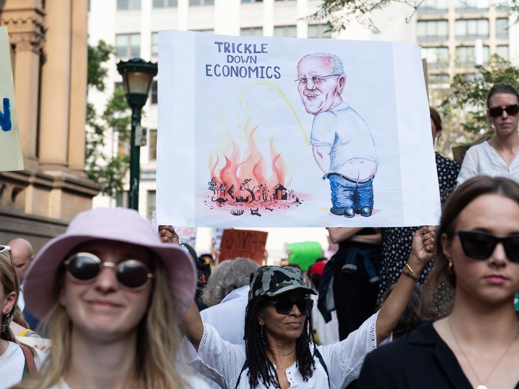 A woman holds up a sign at a climate action rally in Sydney, on Friday, January 10, 2019. (AAP Image/Michael Bilbe-Taylor)